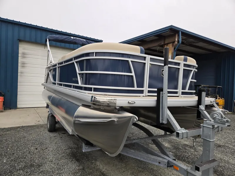 Slide: The Image of 2025 Godfrey Sweetwater 2086 C pontoon boat on trailer near blue building. - 6