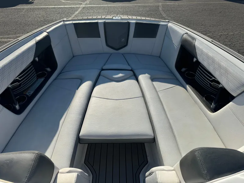 Slide: The Image of 2017 Nautique G25 boat interior with cushioned seating and cup holders. - 11