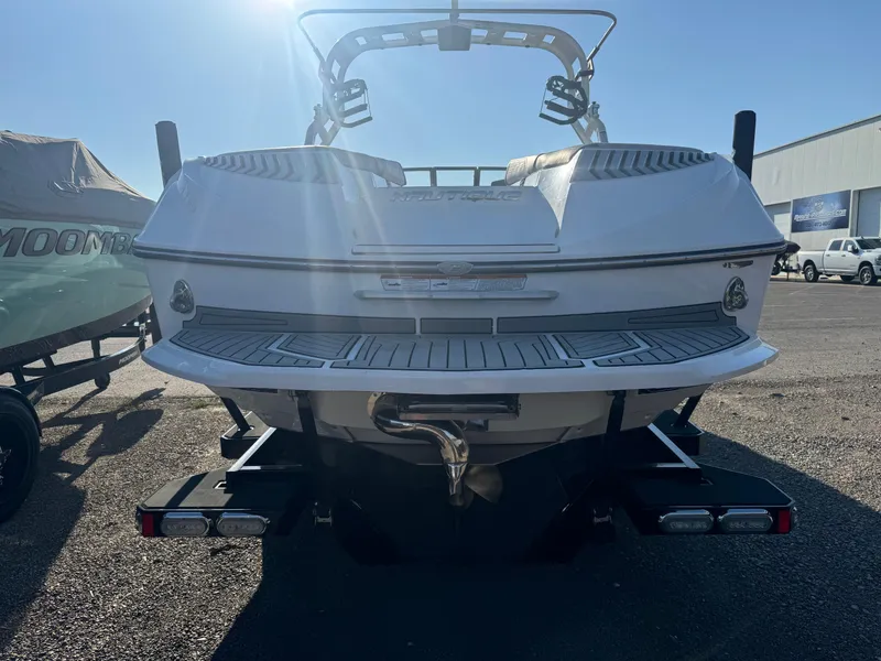 Slide: The Image of 2017 Nautique G25 boat rear view in a sunny outdoor setting. - 3