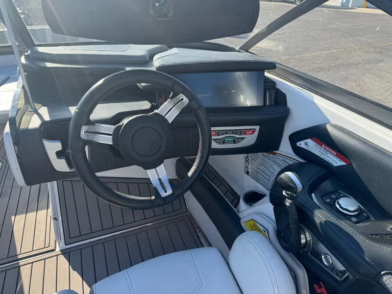 Slide: The Image of 2017 Nautique G25 boat cockpit with steering wheel and control panel. - 9