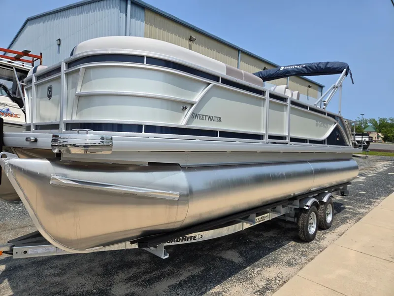 Slide: The Image of 2025 Godfrey SWEETWATER 2286 SFL pontoon boat on trailer, parked outdoors. - 1