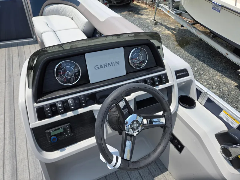 Slide: The Image of 2025 Godfrey SWEETWATER 2286 SFL boat dashboard with Garmin display and steering wheel. - 13