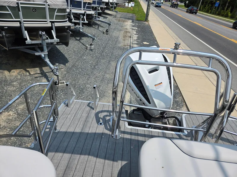 Slide: The Image of 2025 Godfrey SWEETWATER 2286 SFL pontoon boat with outboard motor, parked near road. - 21