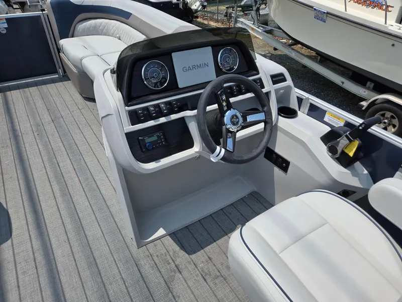 Slide: The Image of 2025 Godfrey SWEETWATER 2286 SFL boat interior with Garmin navigation system and steering wheel. - 30