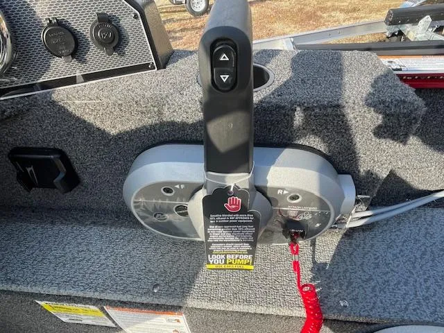 Slide: The Image of 2025 Lund 1650 Angler SS boat control panel with safety warning tag. - 11