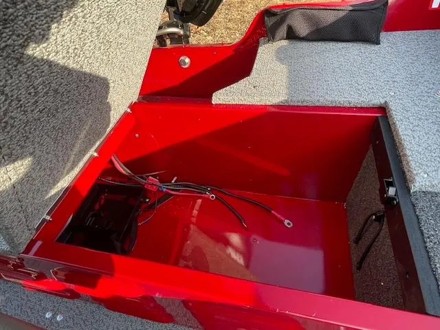 Slide: The Image of 2025 Lund 1650 Angler SS boat storage compartment with red interior and wiring. - 12