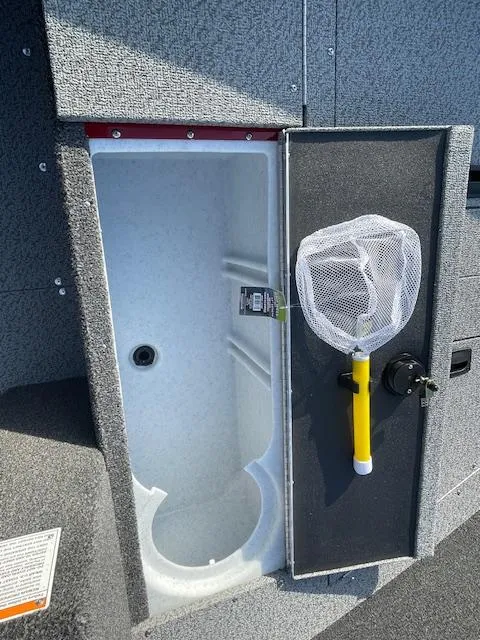 Slide: The Image of 2025 Lund 1650 Angler SS livewell with net storage, open compartment view. - 16