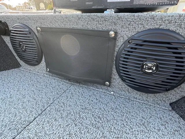 Slide: The Image of 2025 Lund 1650 Angler SS boat interior with dual speakers and carpeted finish. - 18