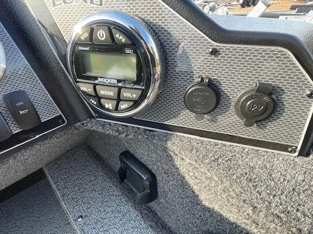 Slide: The Image of 2025 Lund 1650 Angler SS dashboard with audio controls and 12V power outlet. - 7