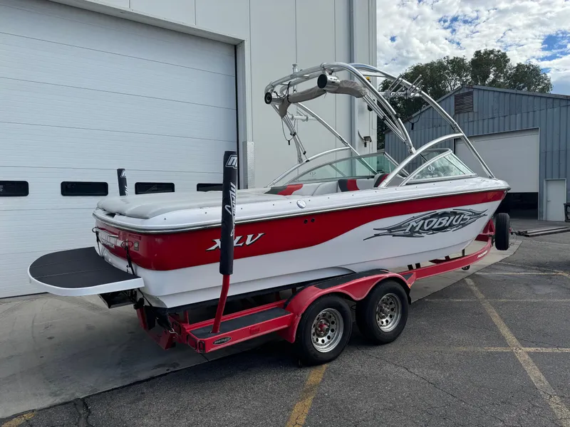 Slide: The Image of 2006 Moomba XLV boat on red trailer near industrial building. - 3