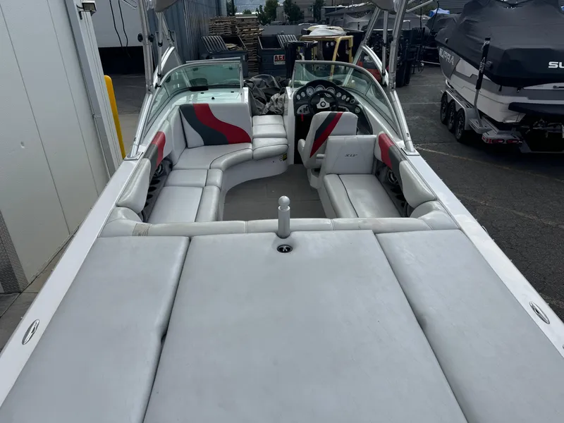 Slide: The Image of 2006 Moomba XLV boat interior with white and red seating, parked outdoors. - 5