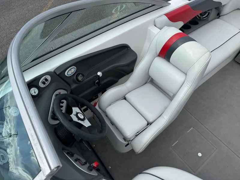 Slide: The Image of 2006 Moomba XLV boat interior with white and red seating, steering wheel, and dashboard controls. - 9