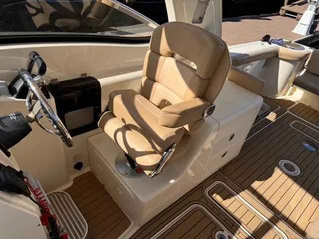 Slide: The Image of 2018 Scout 275 Dorado boat interior with tan captain's chair and steering wheel. - 11