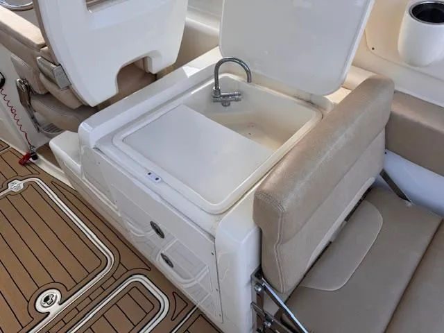 Slide: The Image of 2018 Scout 275 Dorado boat interior with sink and seating area. - 16