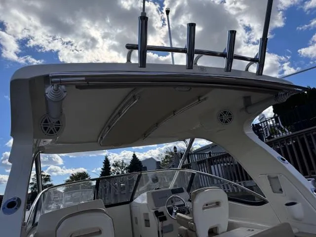Slide: The Image of 2018 Scout 275 Dorado boat interior with seating and steering wheel under a clear sky. - 18