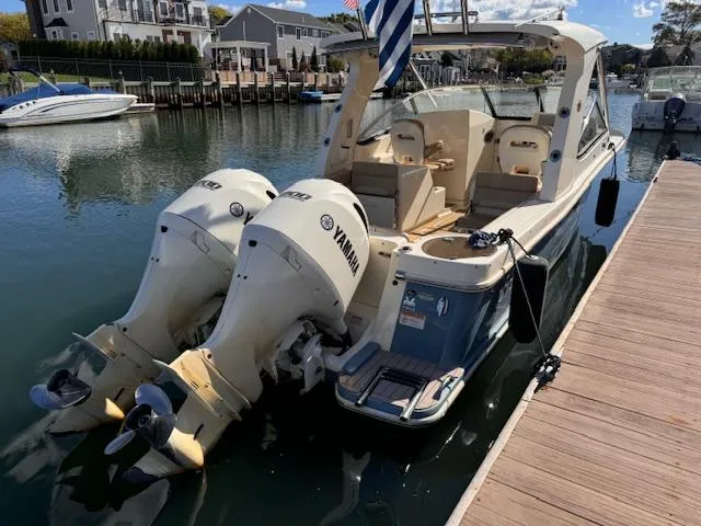 Slide: The Image of 2018 Scout 275 Dorado boat with twin Yamaha engines docked in a marina. - 2