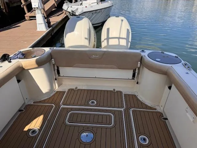 Slide: The Image of 2018 Scout 275 Dorado boat interior with teak flooring and dual engines at dock. - 4
