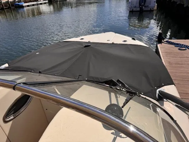 Slide: The Image of 2018 Scout 275 Dorado boat docked, featuring a covered bow area. - 9