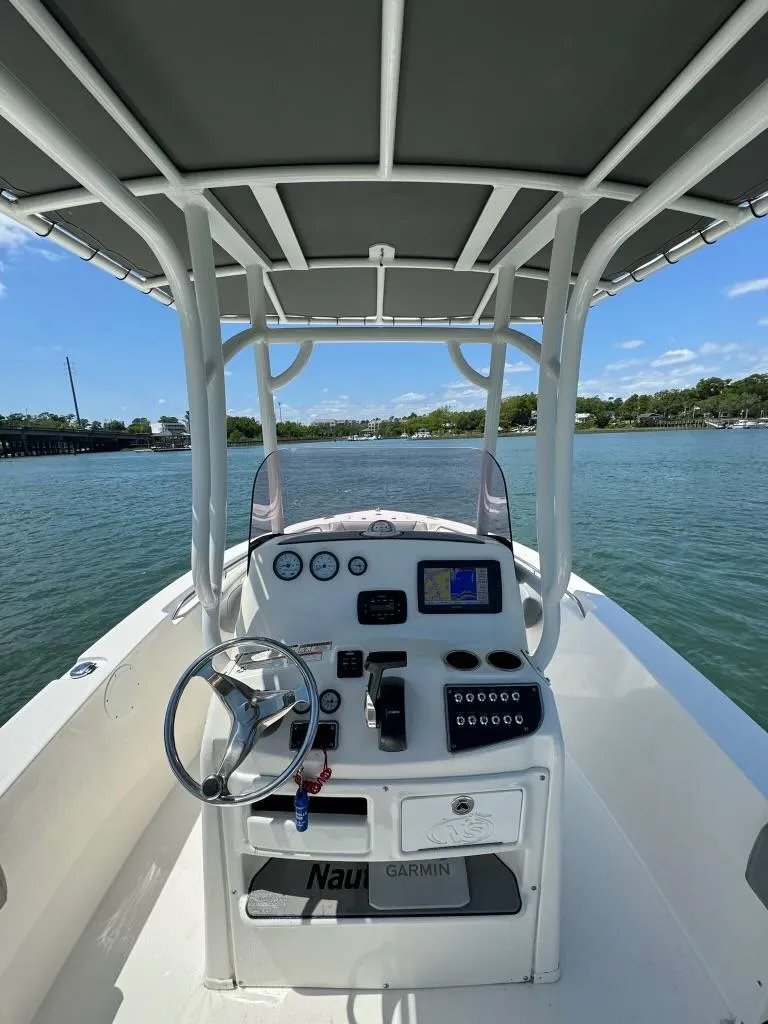 Slide: The Image of 2022 NauticStar 2102 Legacy boat dashboard on calm water. - 10