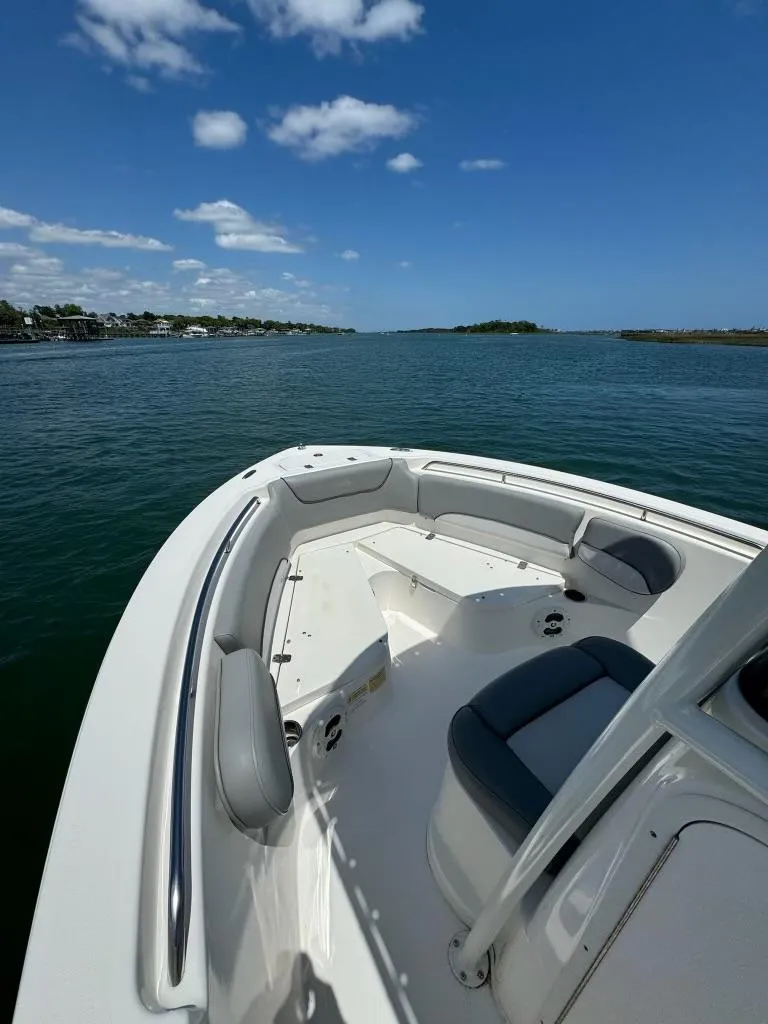 Slide: The Image of 2022 NauticStar 2102 Legacy boat on calm water under blue sky. - 12