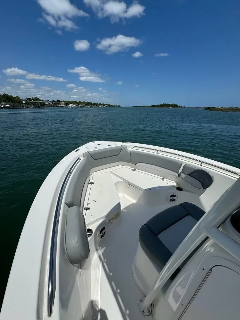 Slide: The Image of 2022 NauticStar 2102 Legacy boat on calm water under a clear blue sky. - 14