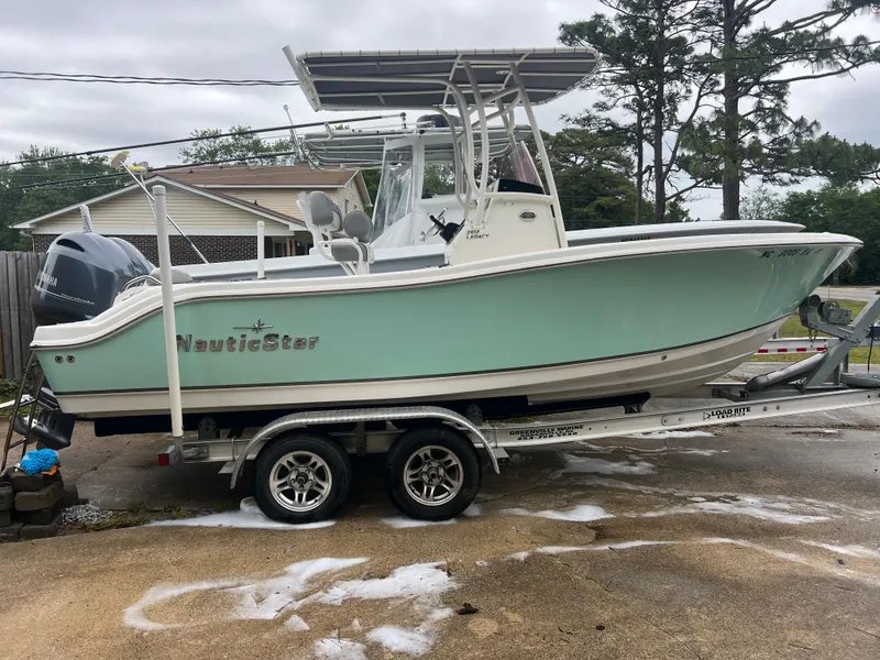 Slide: The Image of 2022 NauticStar 2102 Legacy boat on trailer, light green hull, parked outdoors. - 16