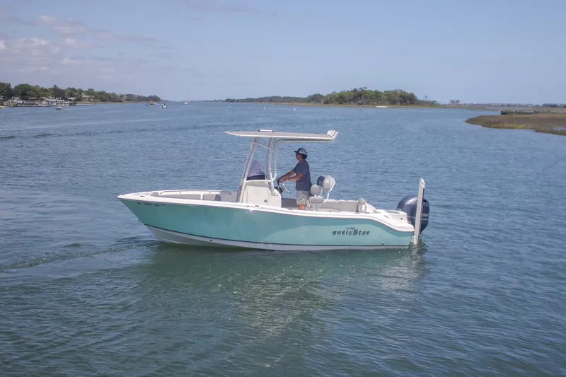 Slide: The Image of 2022 NauticStar 2102 Legacy boat cruising on a calm waterway. - 4