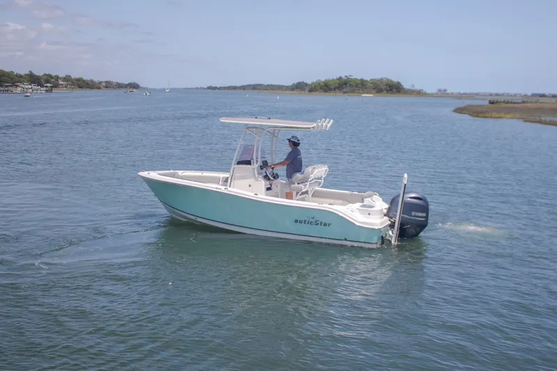 Slide: The Image of 2022 NauticStar 2102 Legacy boat cruising on a calm waterway. - 5
