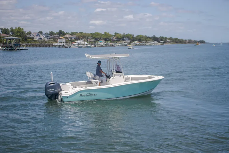 Slide: The Image of 2022 NauticStar 2102 Legacy boat cruising on a calm lake. - 7