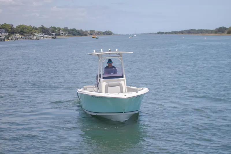 Slide: The Image of 2022 NauticStar 2102 Legacy boat cruising on a calm river. - 9