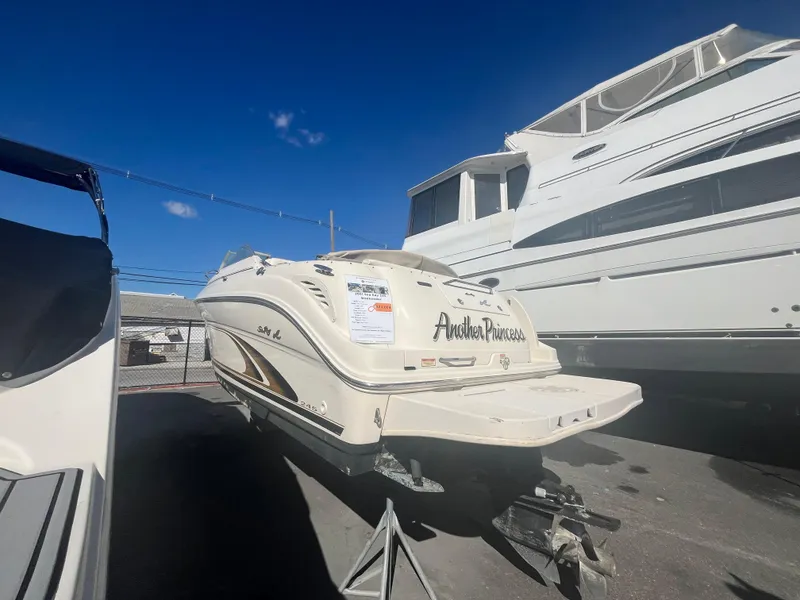 The Image of 2001 Sea Ray 245 Weekender boat on trailer under clear blue sky. - 0