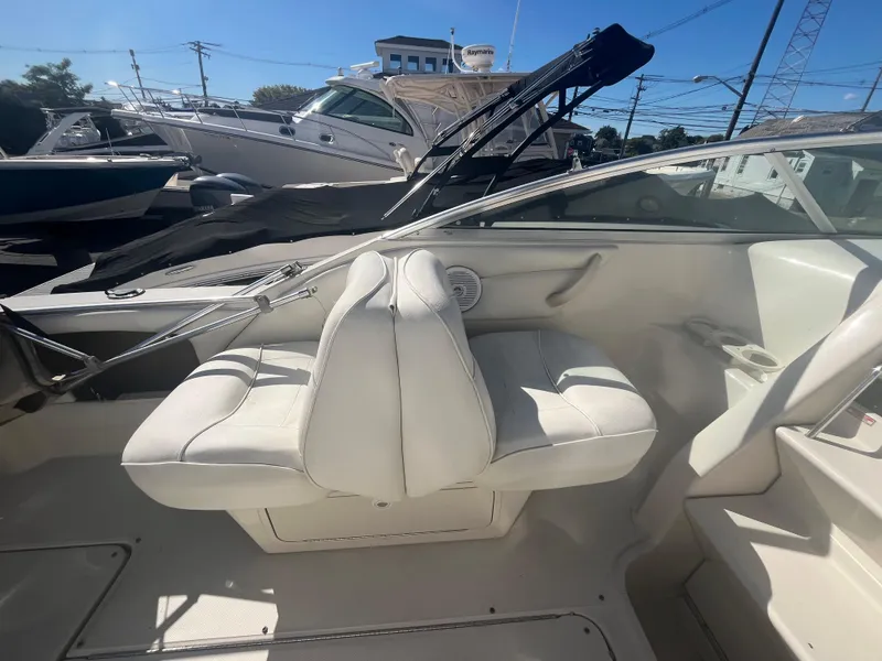 Slide: The Image of 2001 Sea Ray 245 Weekender boat interior with white seating and dashboard. - 11