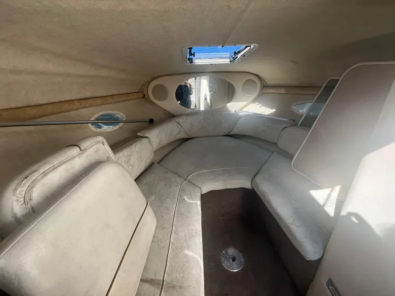Slide: The Image of Interior of 2001 Sea Ray 245 Weekender boat, featuring cozy seating and natural light. - 14