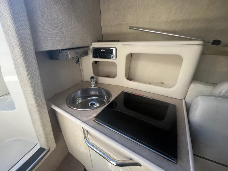 Slide: The Image of 2001 Sea Ray 245 Weekender cabin kitchenette with sink and stove. - 15