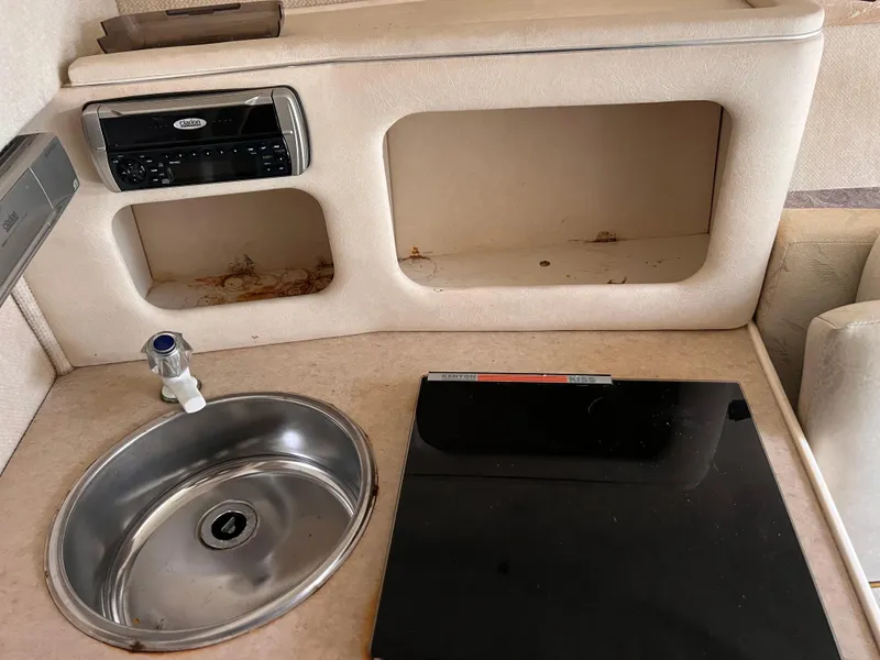 Slide: The Image of 2001 Sea Ray 245 Weekender interior with sink, stove, and stereo system. - 18