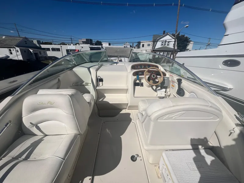 Slide: The Image of 2001 Sea Ray 245 Weekender boat interior with white seating and steering wheel. - 7