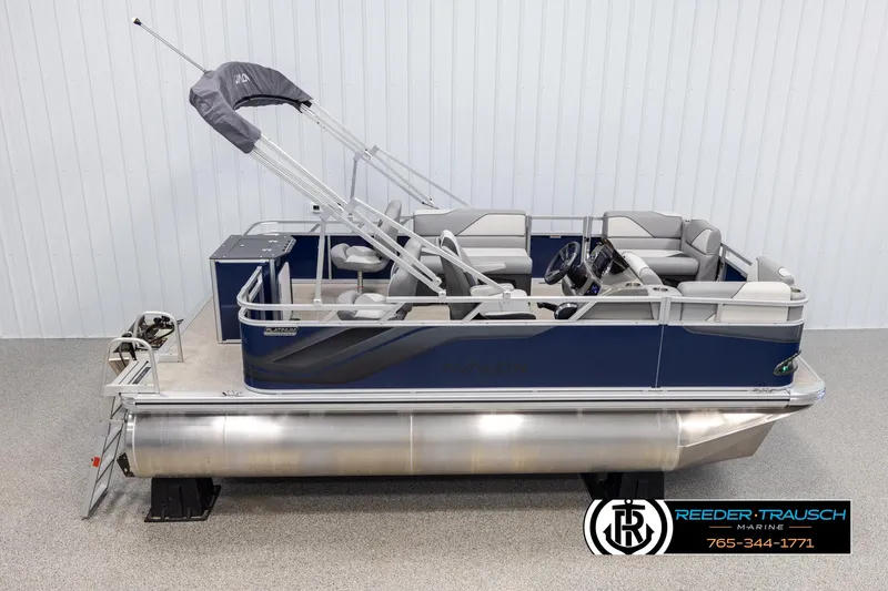 Slide: The Image of 2025 Avalon VEN RF pontoon boat with blue exterior and gray seating, displayed indoors. - 1