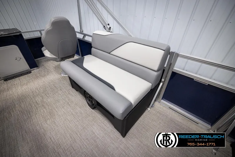 Slide: The Image of 2025 Avalon VEN RF boat interior with gray and white seating, carpeted floor, and Reeder-Trausch Marine logo. - 20
