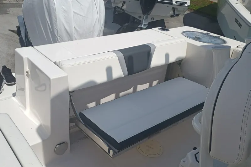 Slide: The Image of 2025 Robalo R230 Center Console boat seating area with white and gray upholstery. - 28