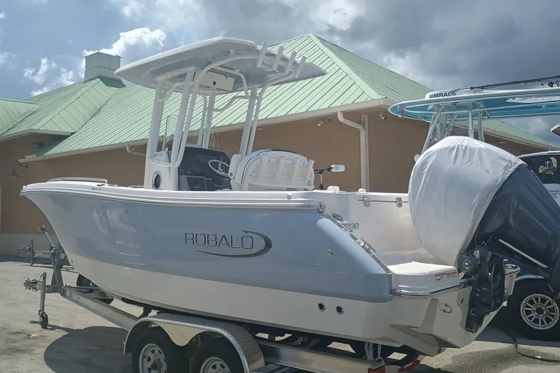 Slide: The Image of 2025 Robalo R230 Center Console boat on trailer, parked outdoors. - 3