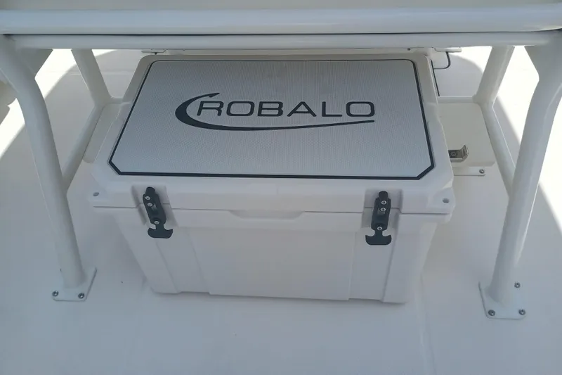 Slide: The Image of 2025 Robalo R230 Center Console cooler under seat, featuring secure latches. - 30