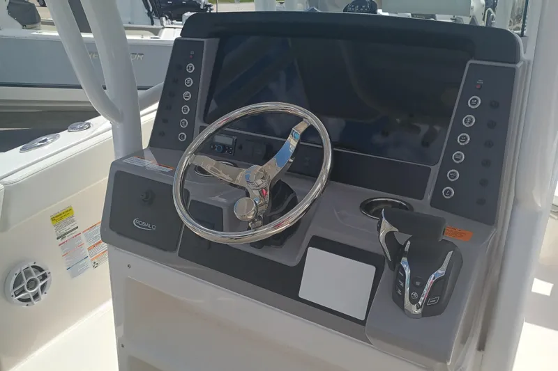 Slide: The Image of 2025 Robalo R230 Center Console boat dashboard with steering wheel and controls. - 8