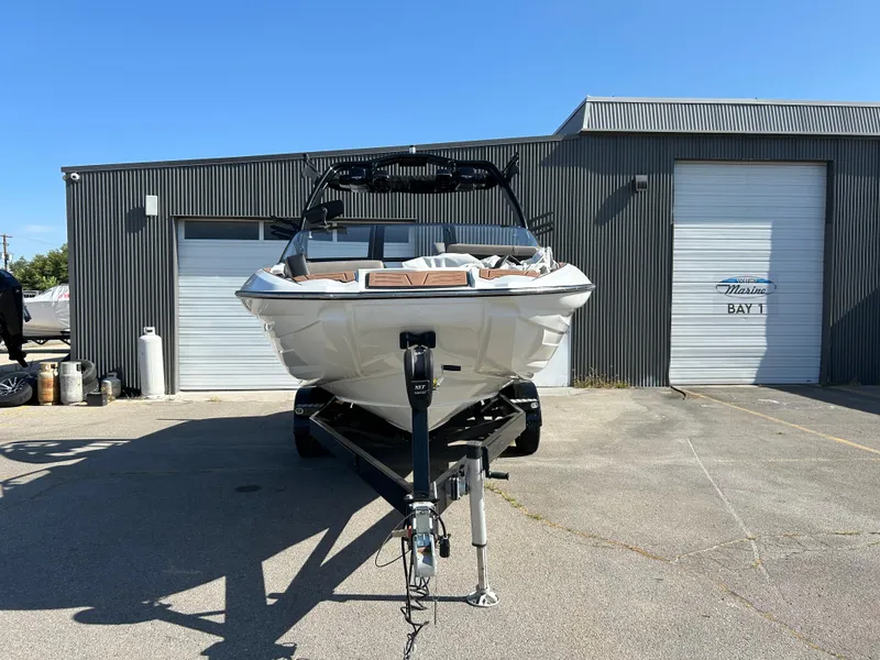 Slide: The Image of 2019 Centurion Fi21 boat on trailer in front of a marina building. - 2