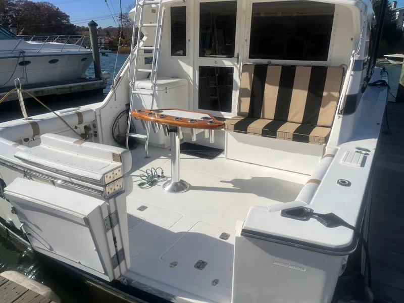 Slide: The Image of 1993 Bertram 37 Convertible yacht with spacious deck and striped seating. - 1