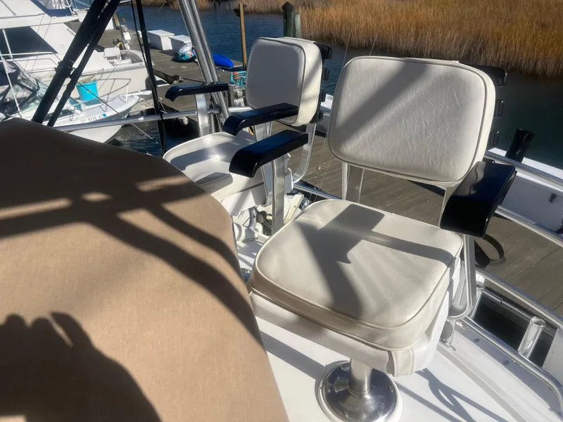 Slide: The Image of 1993 Bertram 37 Convertible boat with white cushioned seats on deck. - 11