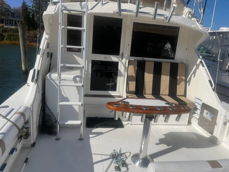 Slide: The Image of 1993 Bertram 37 Convertible yacht deck with seating and fishing rod holders. - 2