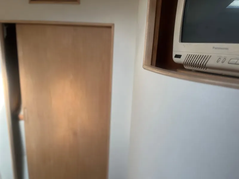 Slide: The Image of Interior of 1993 Bertram 37 Convertible with wooden door and built-in TV. - 31