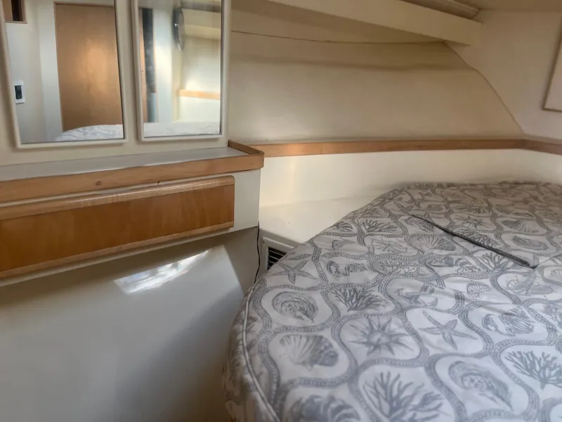 Slide: The Image of Interior cabin of 1993 Bertram 37 Convertible with patterned bedding and wooden accents. - 32