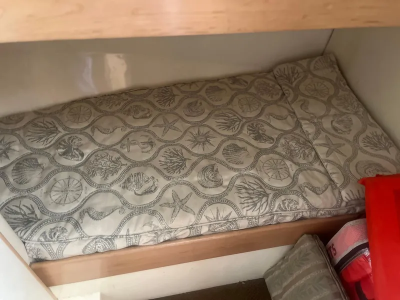 Slide: The Image of Cozy cabin bed in 1993 Bertram 37 Convertible yacht with nautical-themed bedding. - 34