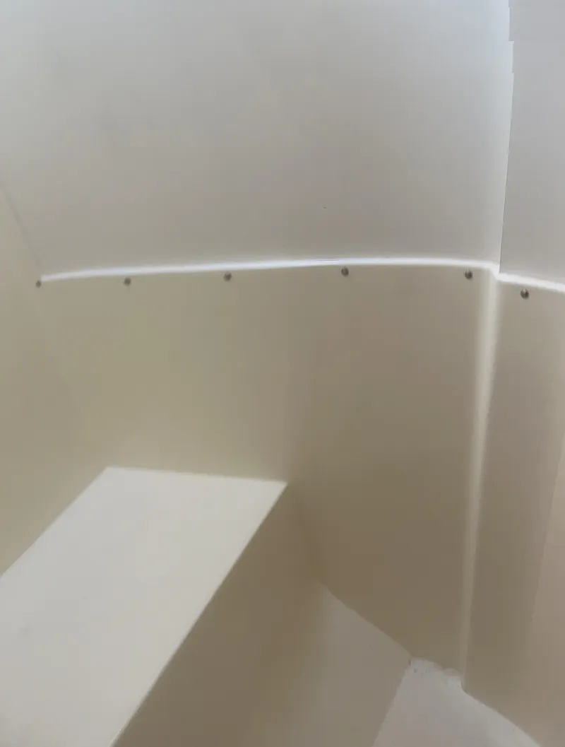 Slide: The Image of Interior of 1993 Bertram 37 Convertible boat, featuring white walls and seating. - 36